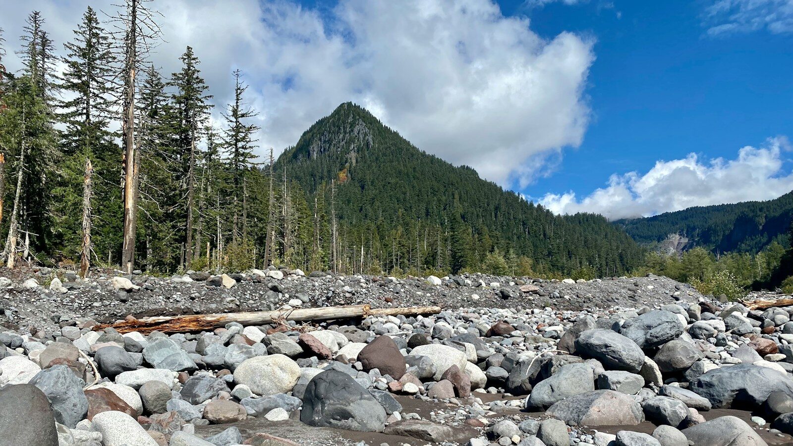 a rocky river bed with a mountain in the background