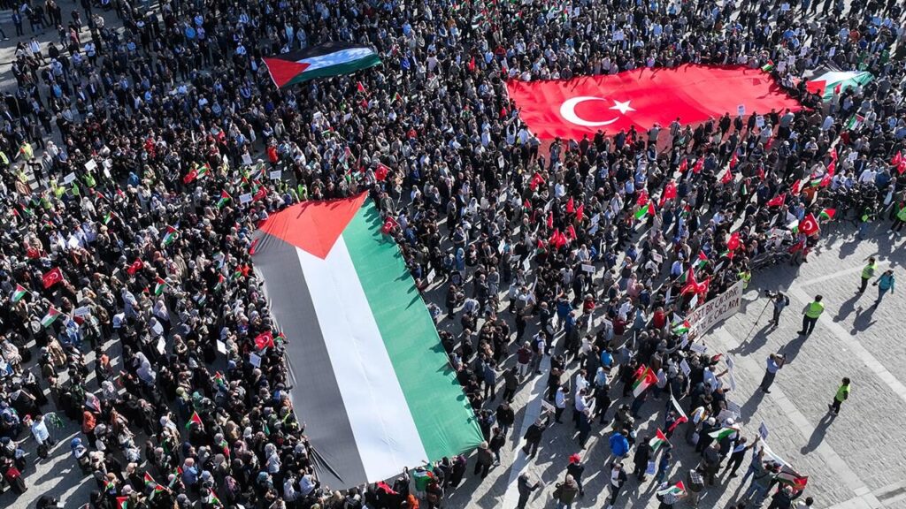 turkish and palestinian flag held by a crowd